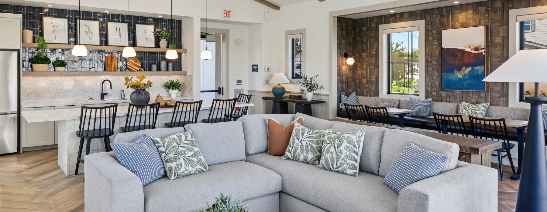 Haven clubhouse lounge with a sectional sofa, kitchen with bar seating, and shuffleboard table
