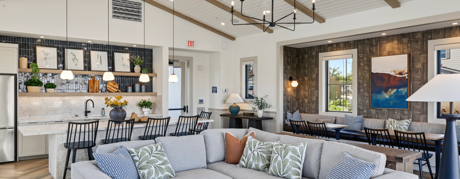 Haven clubhouse lounge with a sectional sofa, kitchen with bar seating, and shuffleboard table